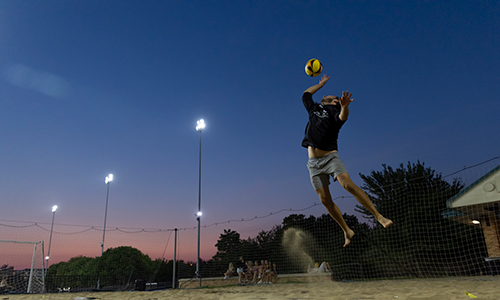 Student playing sand volleyball.