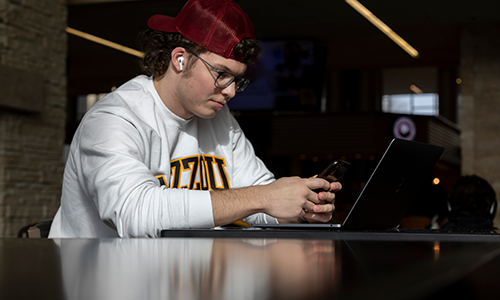 Student on phone at Student Center.