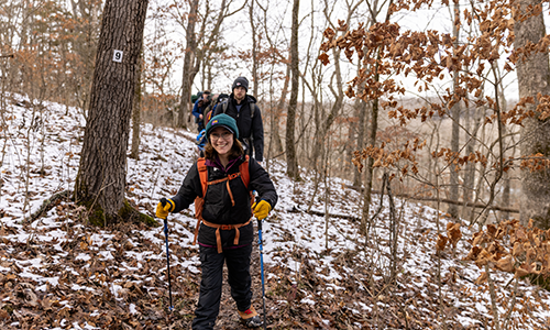 Student walking in woods during course.