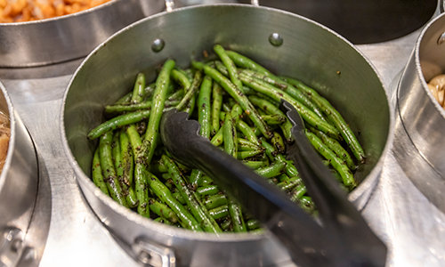 Pot of green beans being served to students.