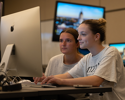 Students looking at computer together.