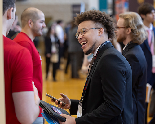 Student talking to employer at career fair.