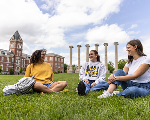 Students sitting together at columns.