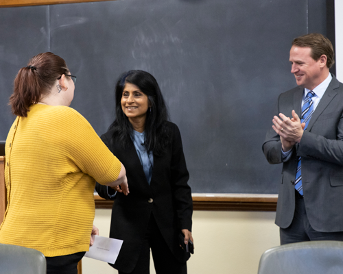 Student shaking hands at fellowship event.