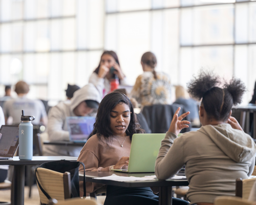 Students on campus on laptop.