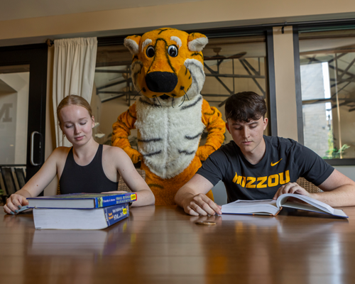 Students sitting at desk with Truman.