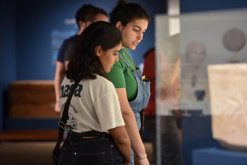 Two student researchers observe the Museum of Art and Archeology.
