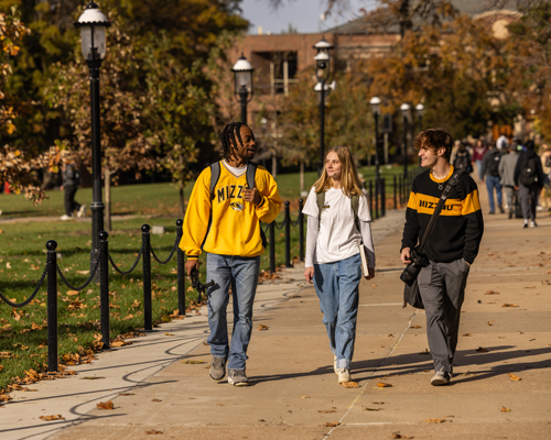 Students walking on campus in Mizzou gear.