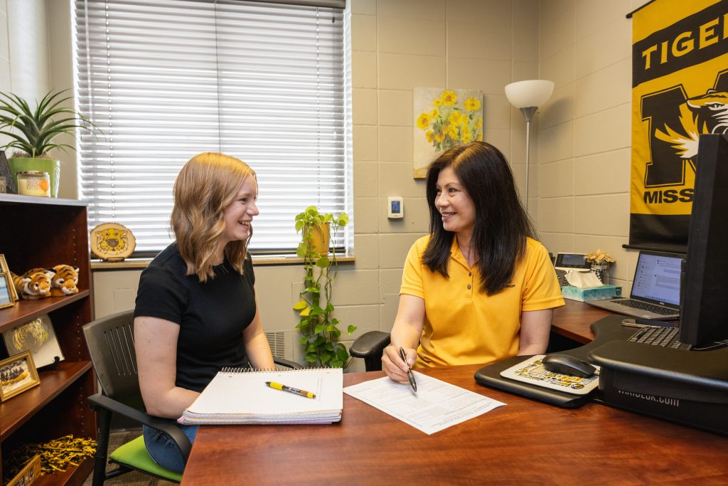 Student meeting with Academic Advisor in office