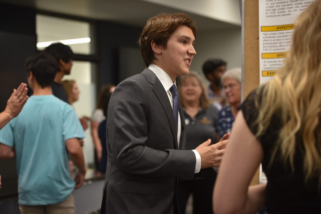 Hunter Hollomon explains his research to another student.