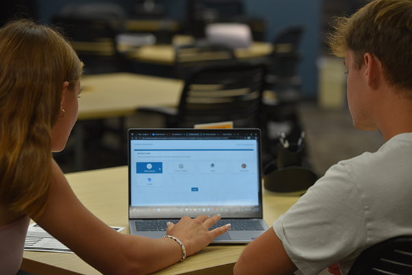 Two students looking at a computer together.