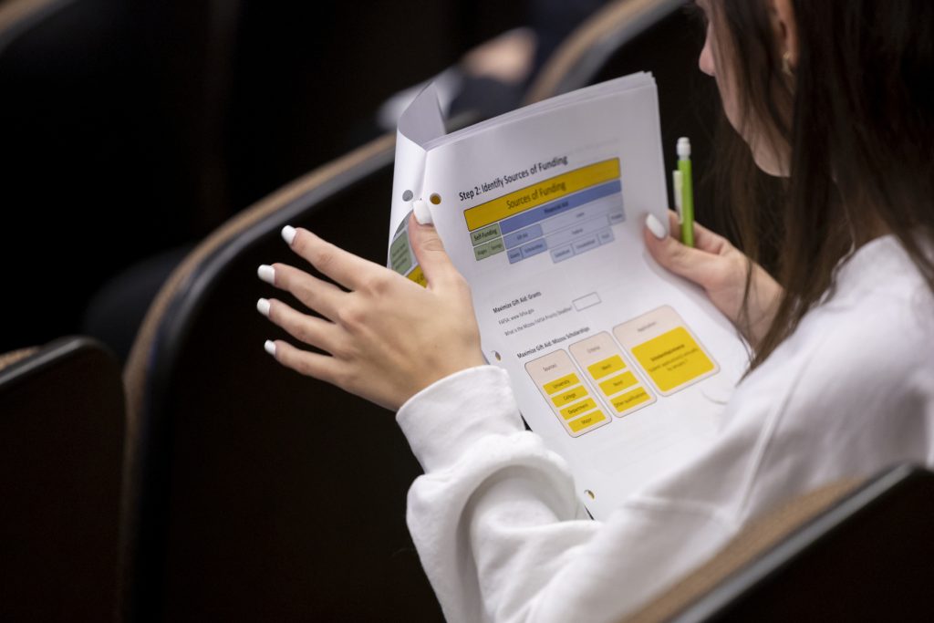 Student holding a financial document.