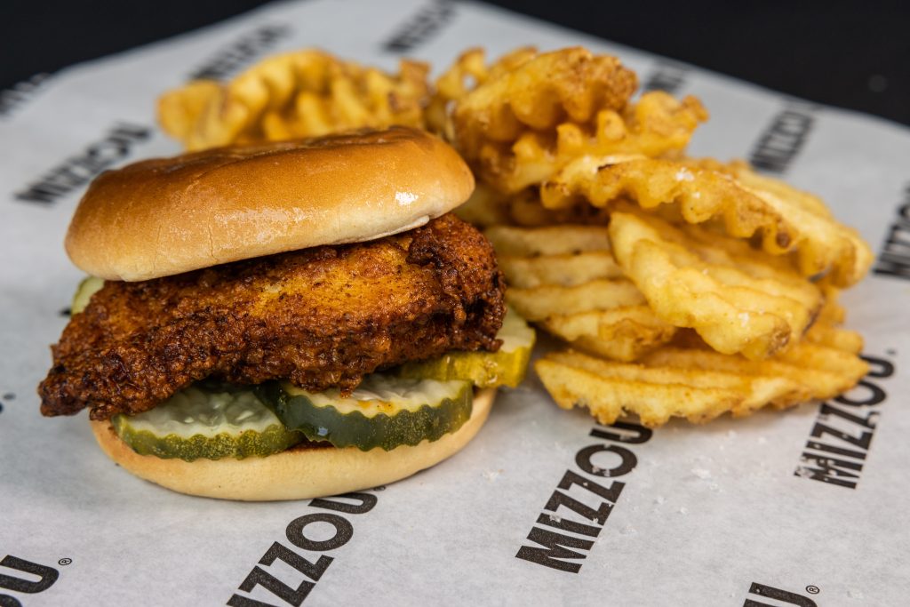 Fried chicken sandwich with pickles on but with waffle fries and Mizzou branded paper
