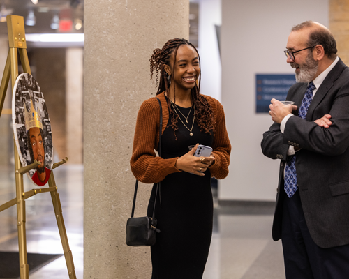 Student presenting art at show.