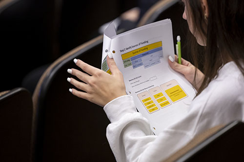 Student holding financial success document.