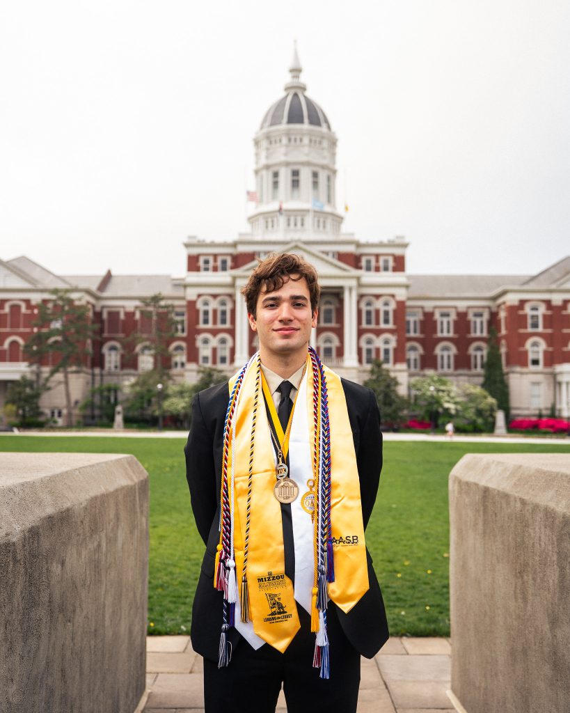 Logan Liguore standing in front of Jesse Hall for graduation pictures. 