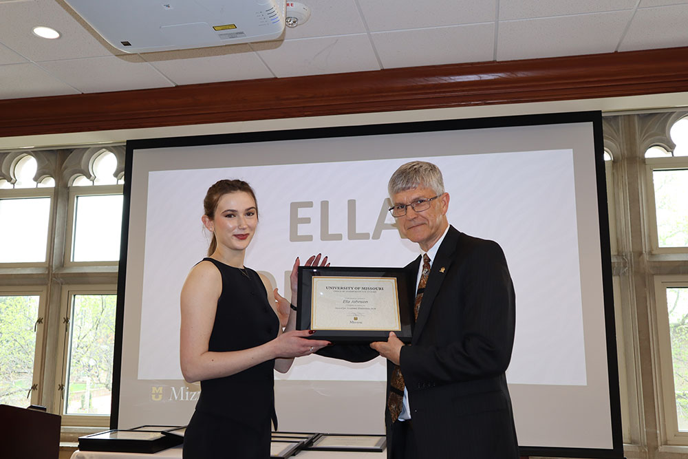 Ella Johnson holding certificate at awards ceremony with Dr. Spain.