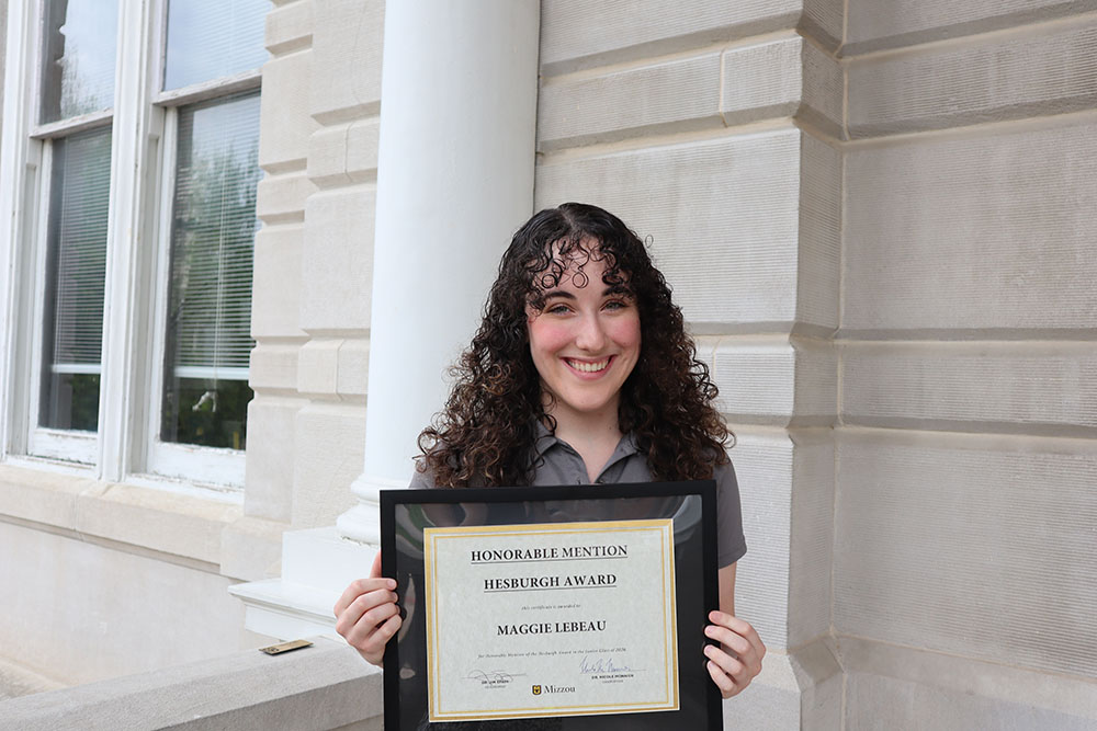 Maggie LeBeau holding certificate.