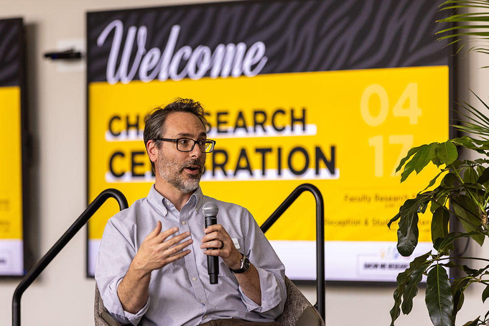 Professor holding microphone and talking.