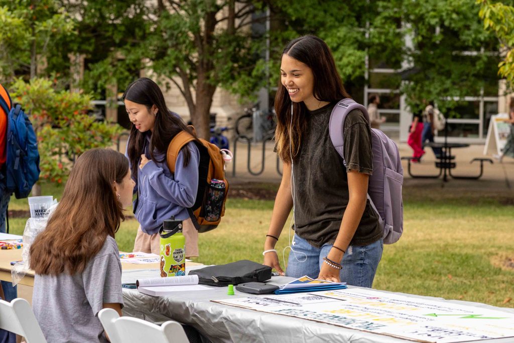 Student talking to a student org booth at the involvement fair.