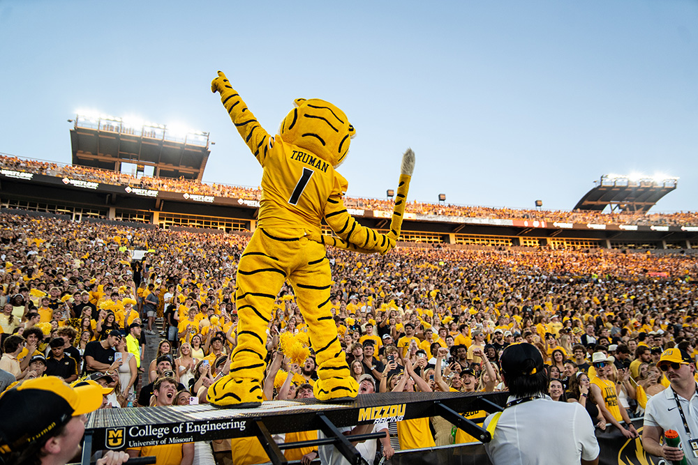 Truman swinging his tail in front of the student section cheering.