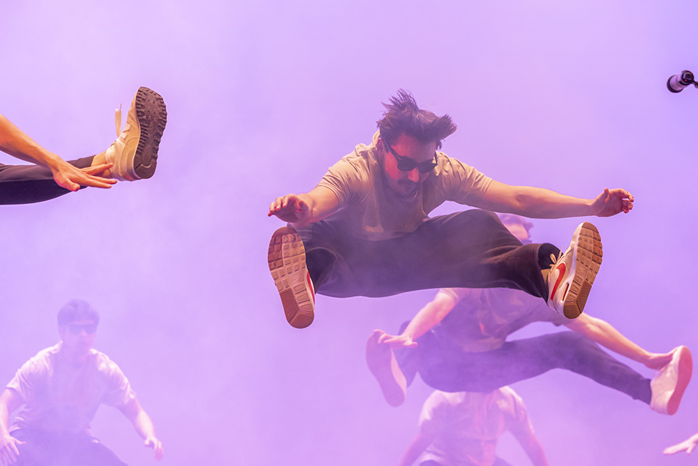 Member of a fraternity doing a toe touch for skit during homecoming week.